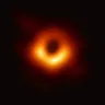 The first image of a black hole, a glowing orange ring around a dark centre