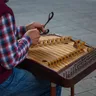 A musician playing the cimbalom with two mallets