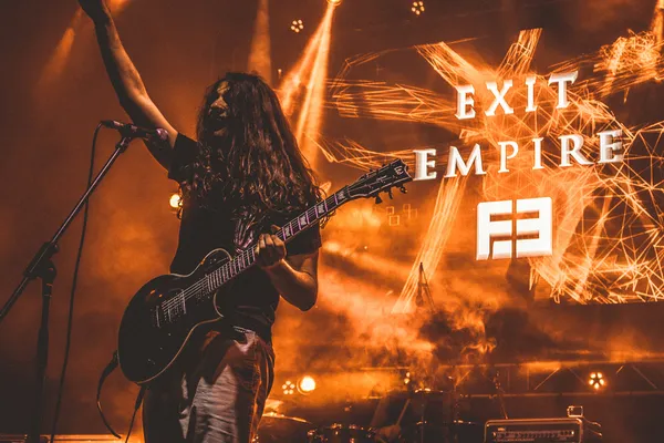 Exit Empire guitarist Timmy Ruzicka live at Rocanotherworld 2018, in orange light
