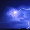 Lightning striking from a storm cloud at dusk